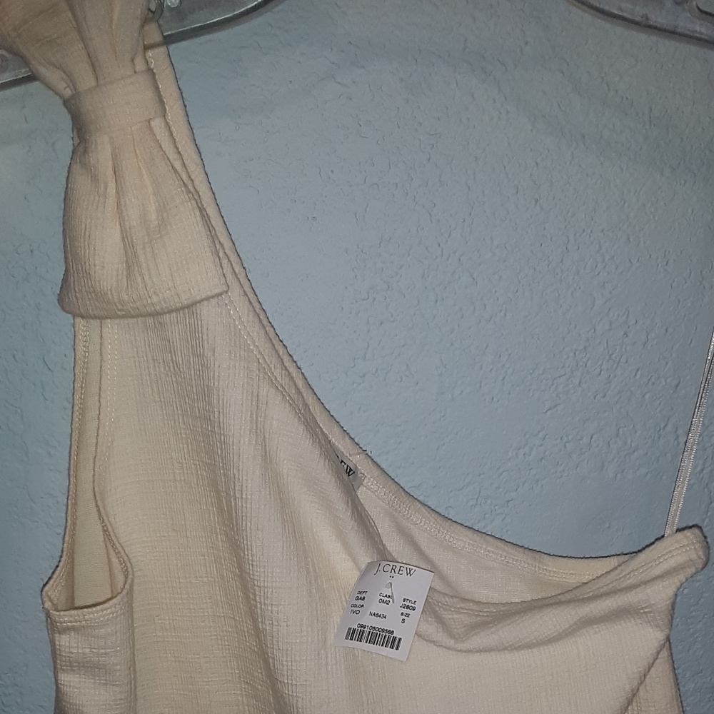 Cream top over one shoulder